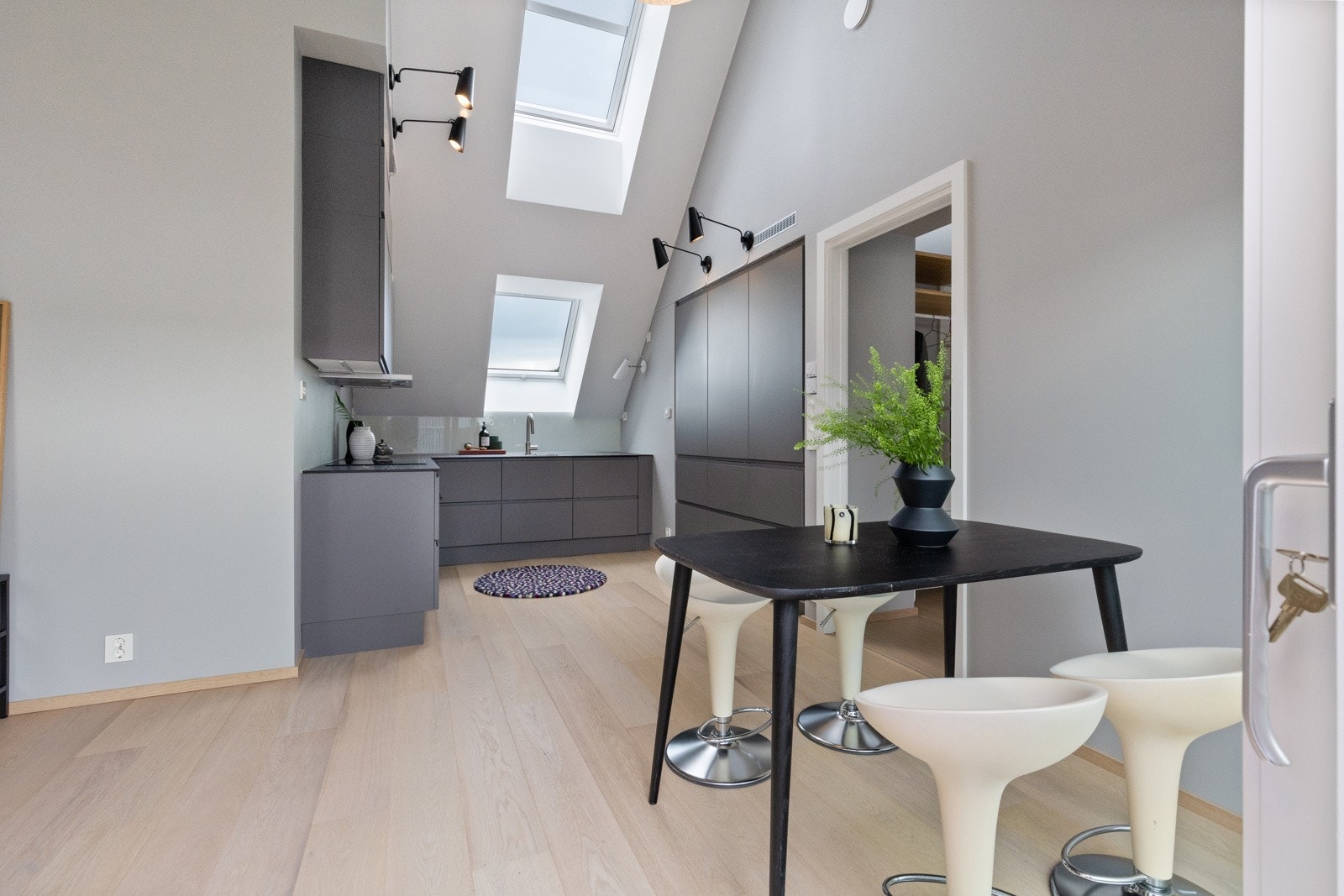 Delikat kjøkken med slette fronter i mørk gråtone. Galleribilde