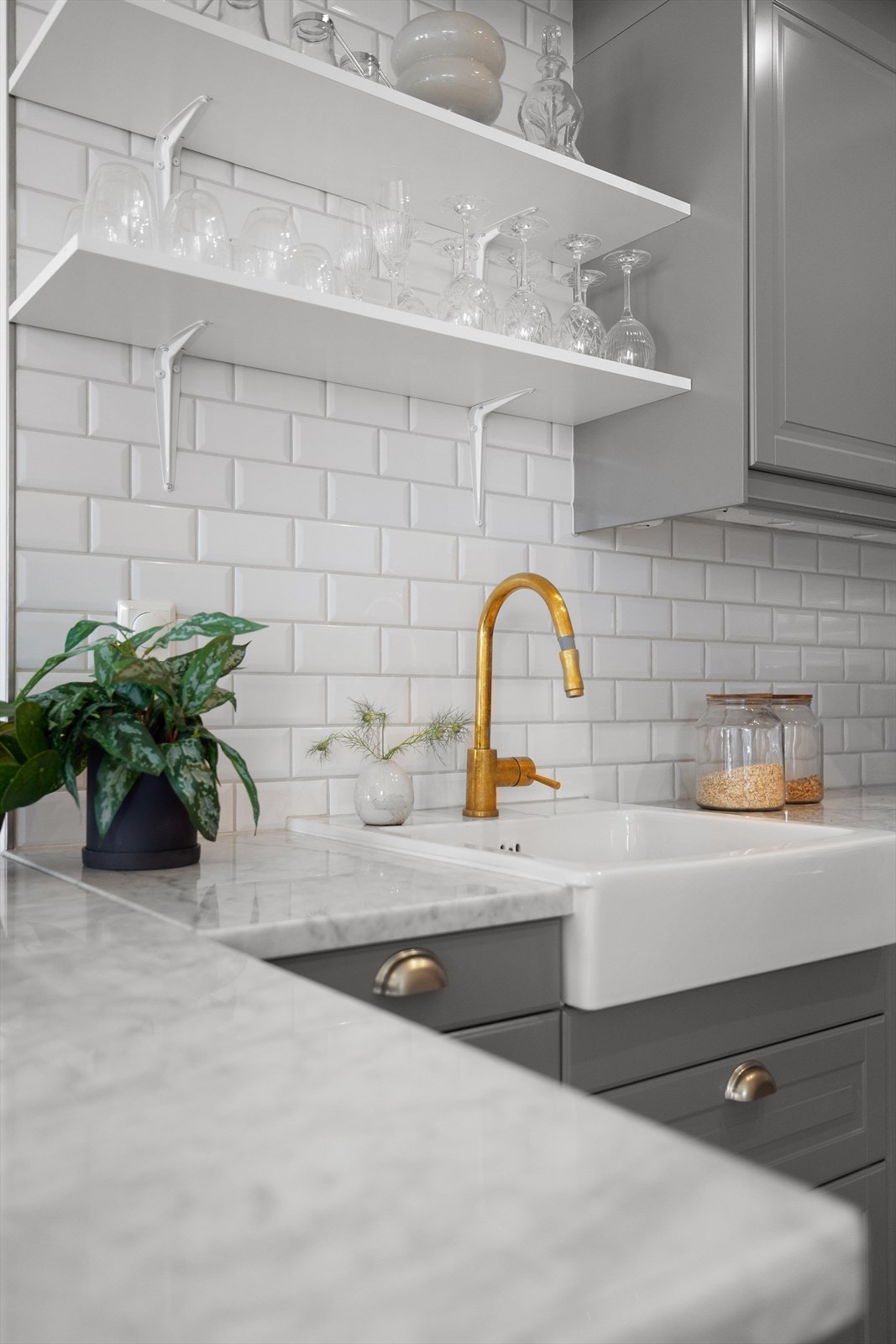 Pen innredning med glatte, lakkerte fronter, flislagt på veggene og marmor benkeplate Galleribilde