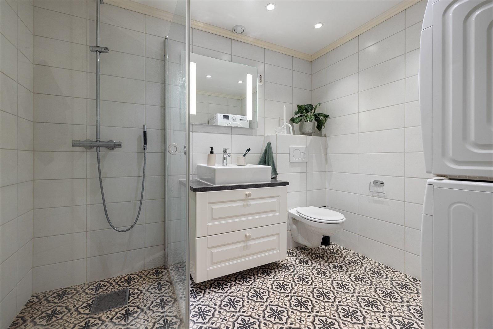 Delikat bad med flislagte overflater, downlights i himling og behagelig gulvvarme. Det er opplegg for vaskemaskin Galleribilde