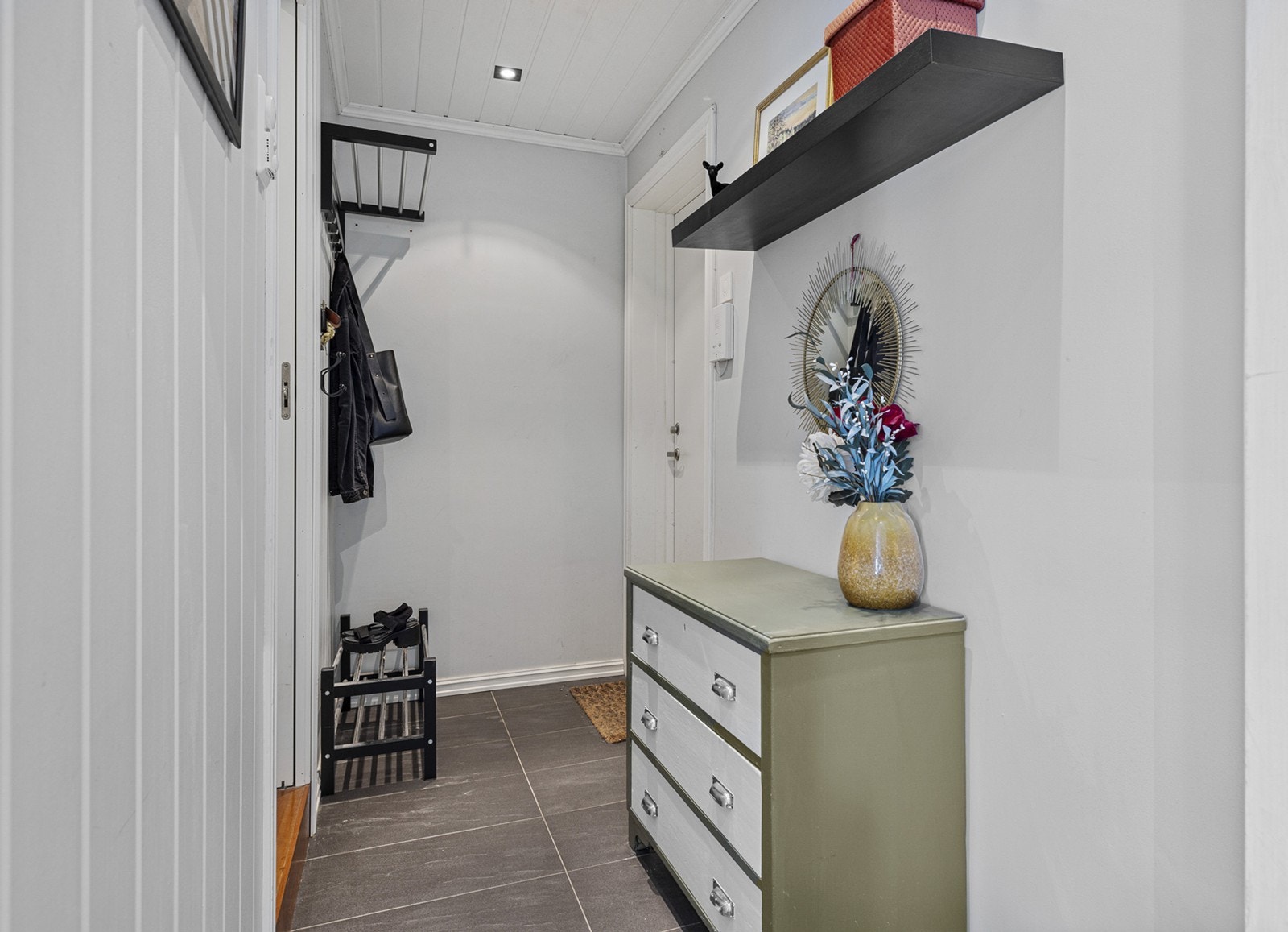 Innenfor døra ønskes man velkommen til en hyggelig entré hvor man kan henge i fra seg yttertøy. Leiligheten byr på rikelig med oppbevaringsplass med en stor skyvedørs garderobe og en bod i samme etasje som leiligheten. Galleribilde