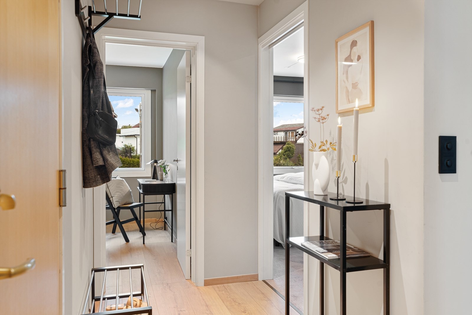 Pen og innbydende gang med slette, malte vegger og laminat på gulv. Her er det plass til å henge fra seg yttertøy og sette fra seg sko. Galleribilde