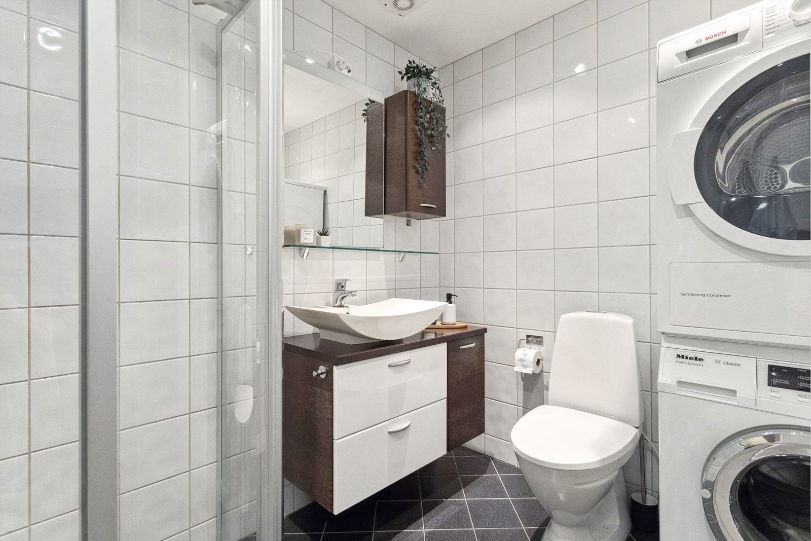 Badet har fliser på vegger og gulv og downlights i tak. Galleribilde