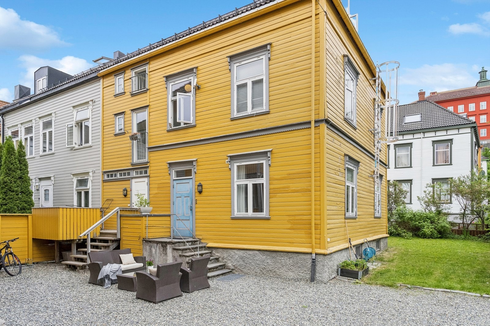 Leiligheten ligger bak den blå døra, trygt plassert i bakgården. Galleribilde
