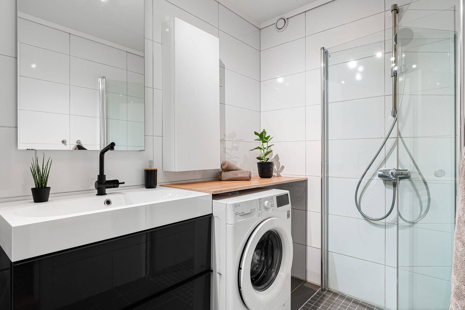 Badet måler 3,90 m² og er helfliset i hvite fliser på vegg, grå fliser på gulv, og har elektriske varmekabler. Galleribilde