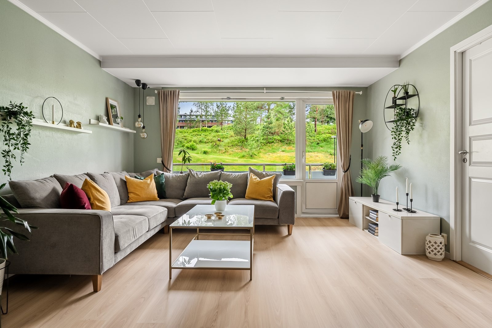 Veggene er av betong og har malte flater i en lys grønn farge som trekker fargene fra landskapet inn i stuen. Galleribilde