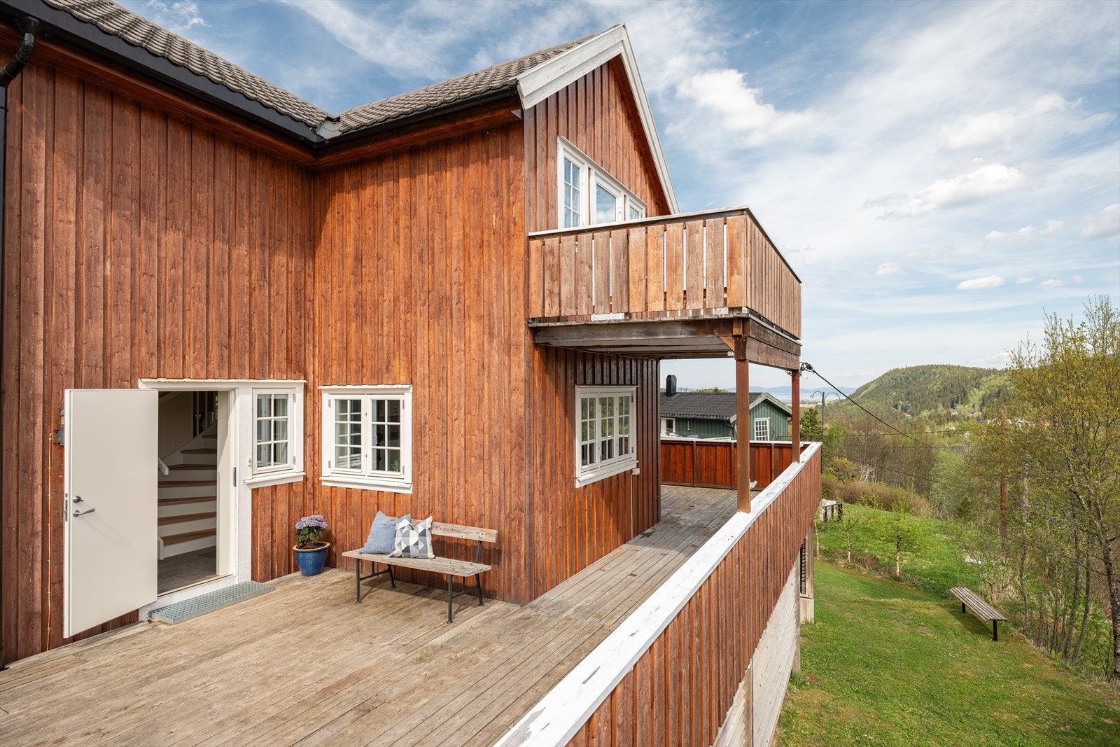 Boligens terrasse strekker seg rundt hele fremsiden av huset. Den gode størrelsen gir muligheter til å møblere balkongen i flere soner, både for store og små. Galleribilde