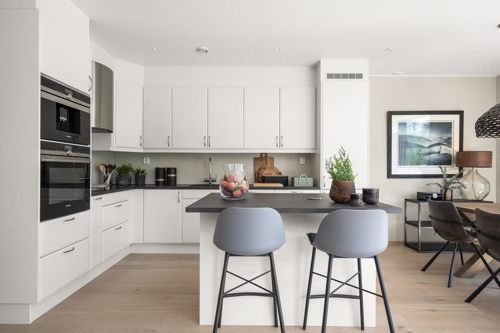 Kjøkkeninnredningen er moderne og elegant med glatte skapfronter og benkeplate av laminat samt nedfelt oppvaskkum og ett-greps armatur. Galleribilde