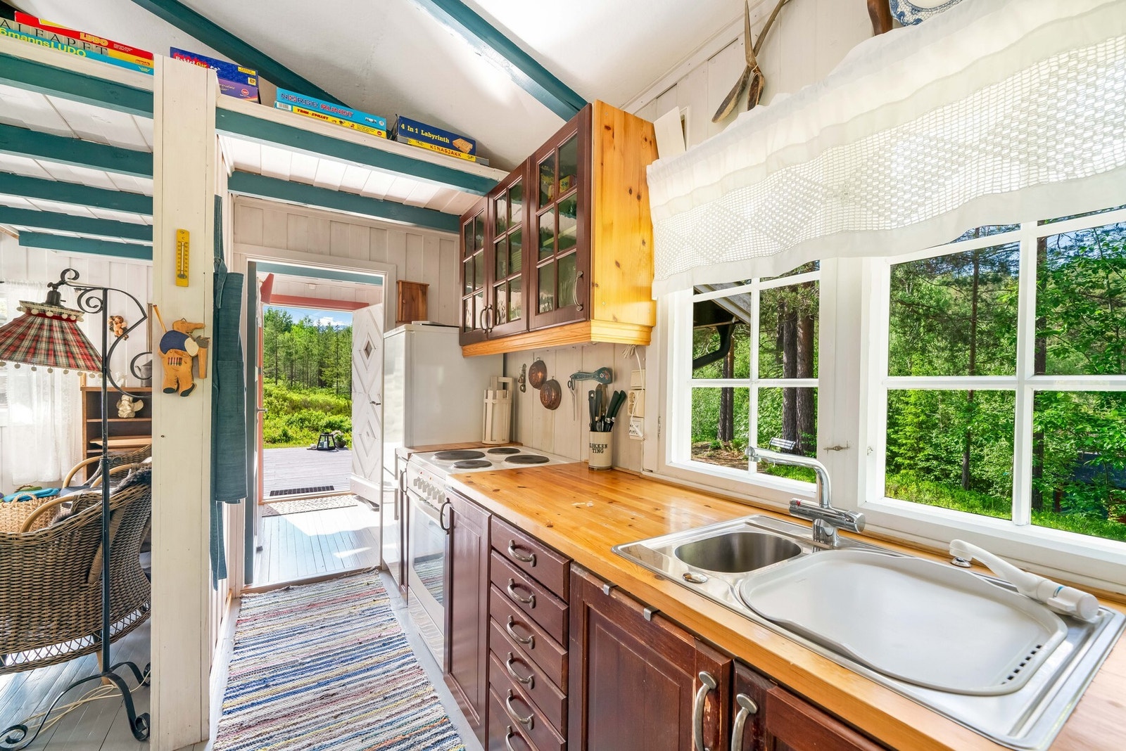 Kjøleskap og elektrisk komfyr og en vask med innlagt sommervann fra cisterne. Galleribilde