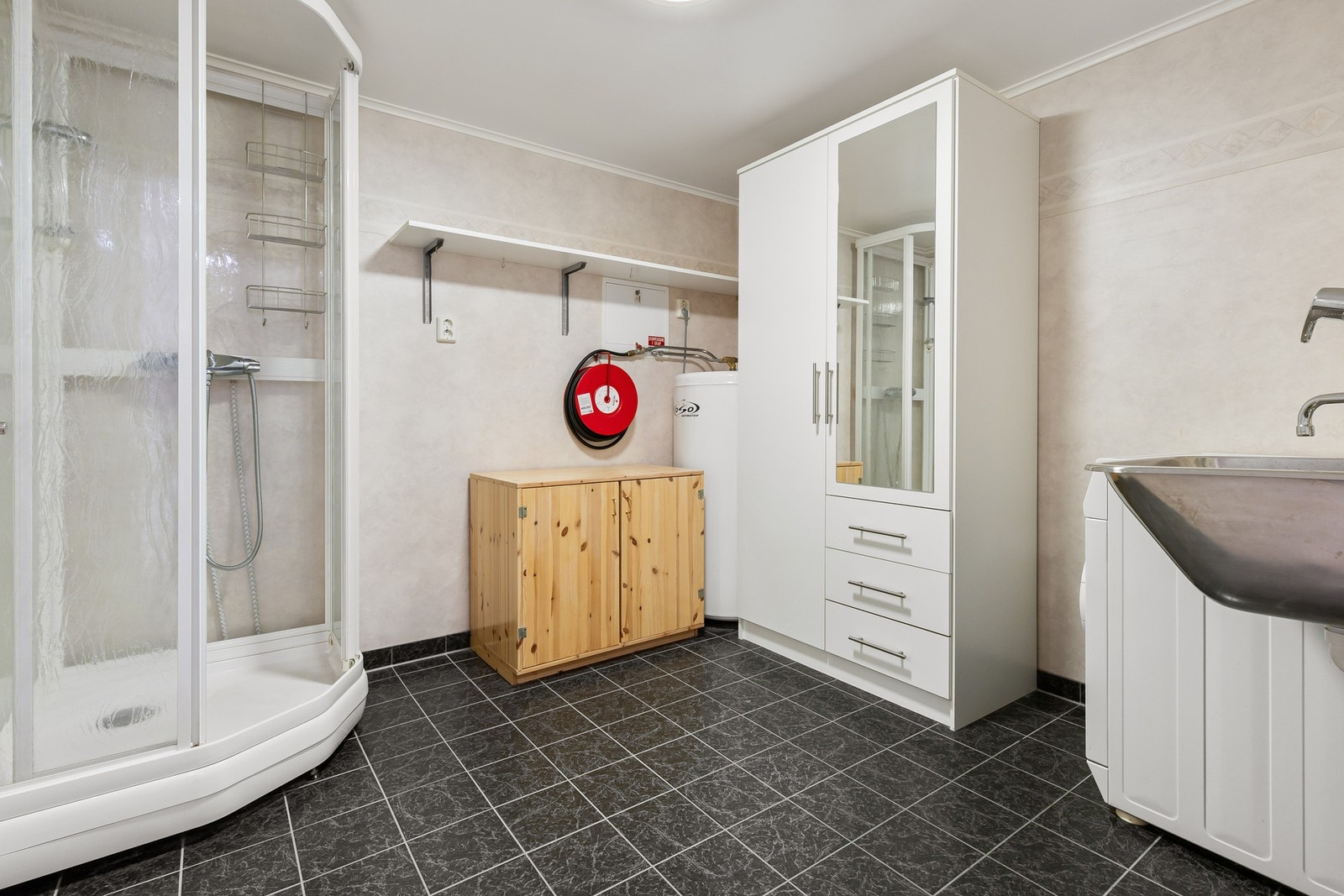 Vaskerommet ligger vegg-i-vegg med badet, med dusjkabinett og opplegg for vaskemaskin. Galleribilde