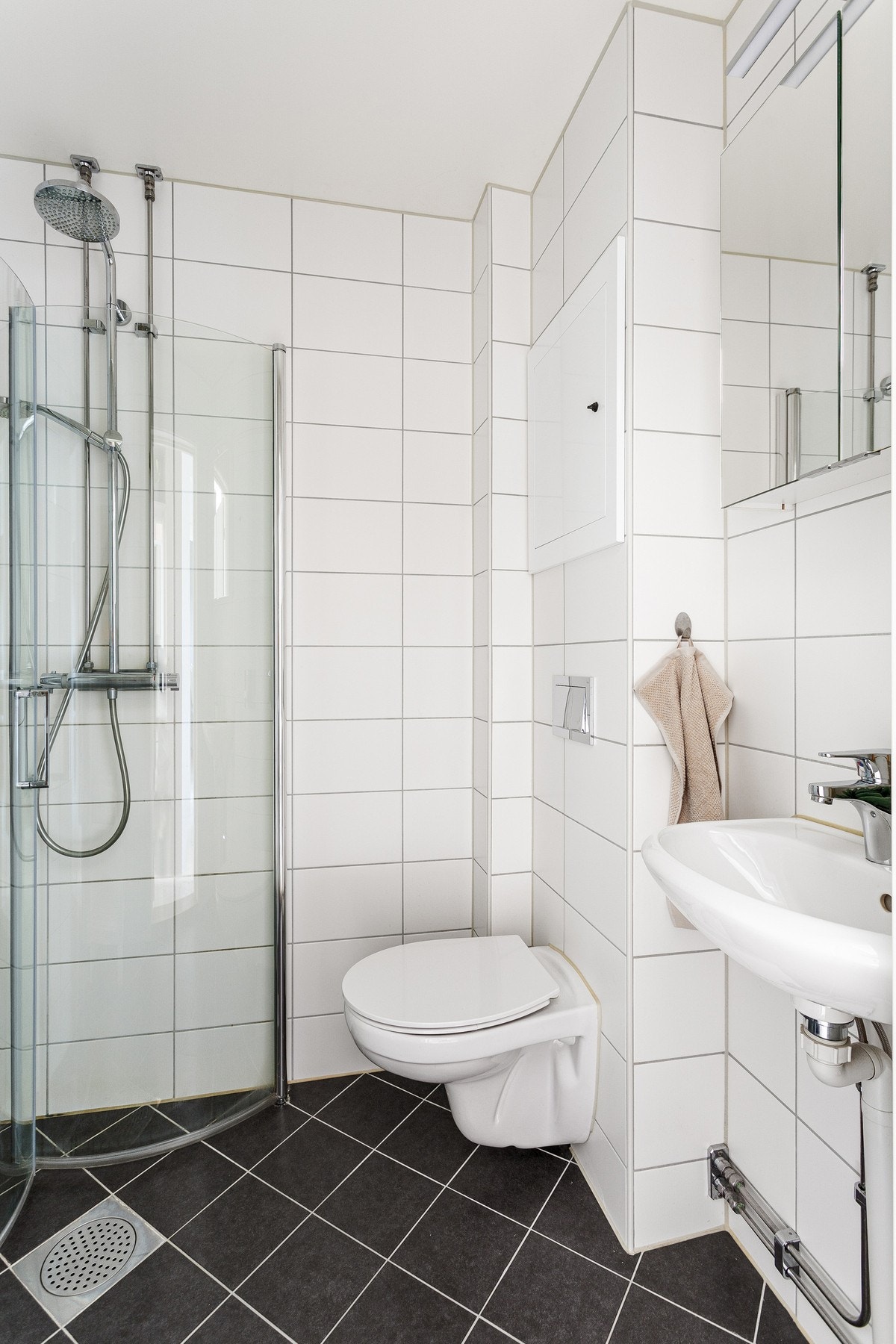 Badet ble pusset opp i regi av borettslaget i 2019 i forbindelse med en total rørutskiftning. Varmekabler og åpen dusj med dusjdører i glass Galleribilde