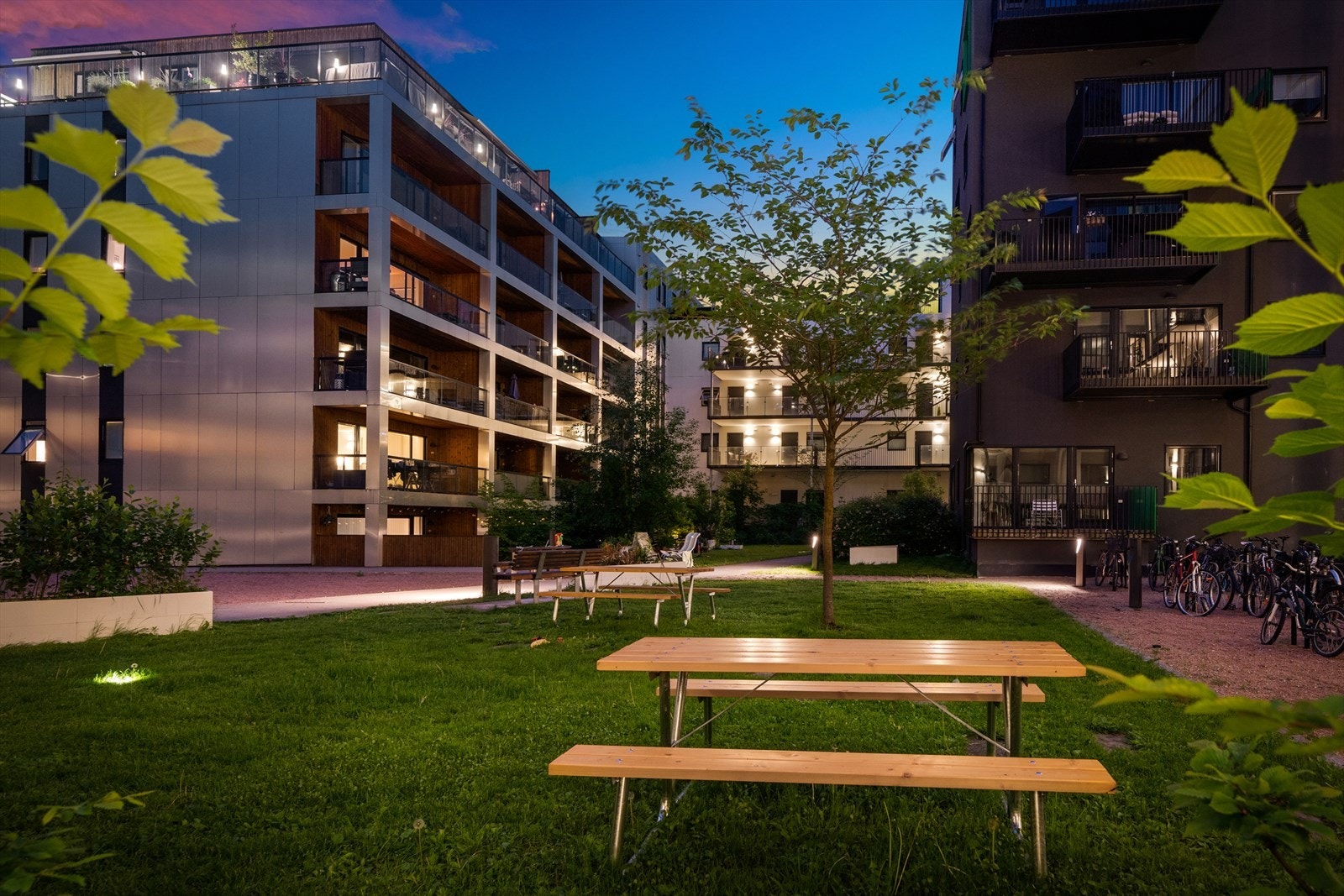 Stor, lukket og pent opparbeidet bakgård med hyggelig belysning. Galleribilde