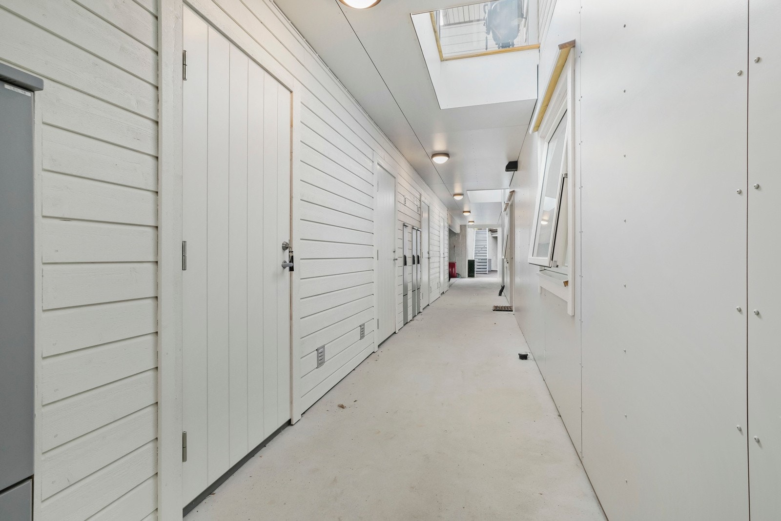 På baksiden av rekka er det svalgang med adkomst til hver sin bod og felles sykkelparkering Galleribilde