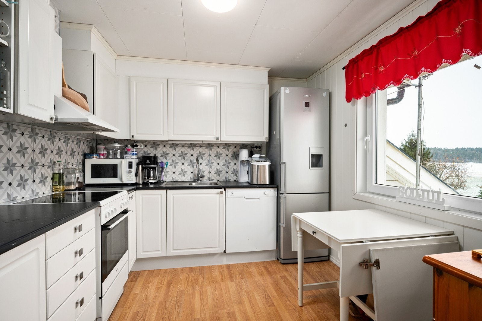 Separat kjøkken i 2. etasje, med en eldre, profilert innredning. Frittstående hvitevarer Galleribilde