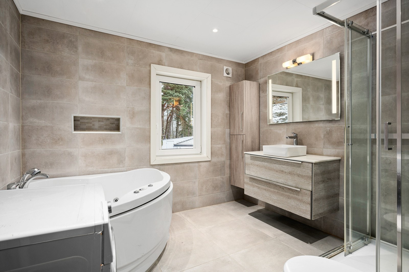 Baderommet i 1. etasje er oppusset - uten dokumentasjon. Det er fliser på gulv og vegger Galleribilde