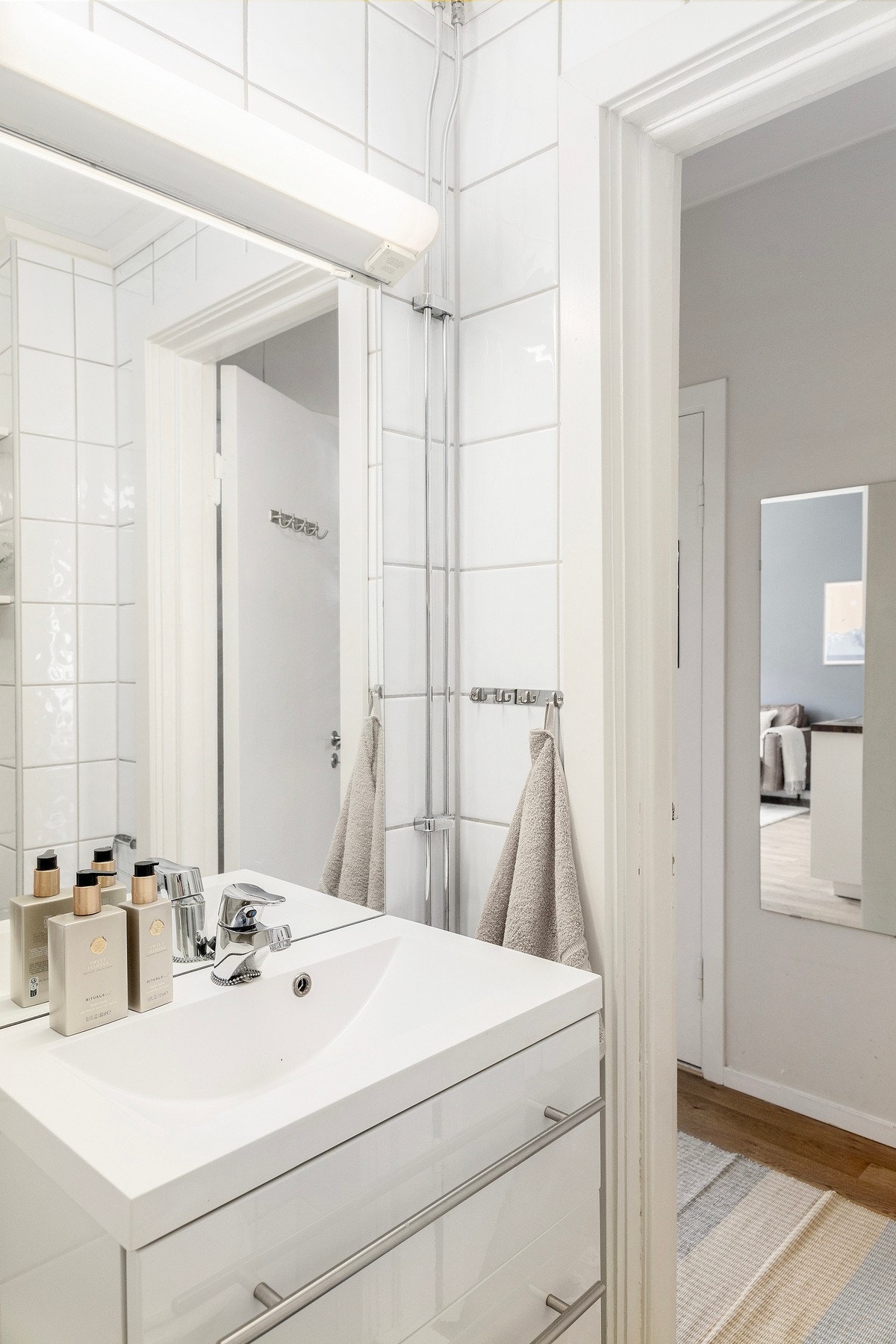 Videre er det servant på underskuffer, speil med lys og vegghyller. Galleribilde