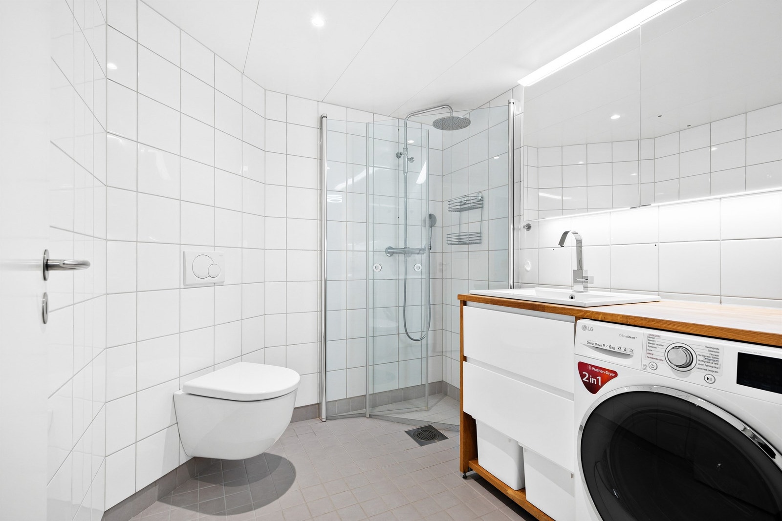 Badet har dusjhjørne med foldedører av glass og regnfallsdusj Galleribilde