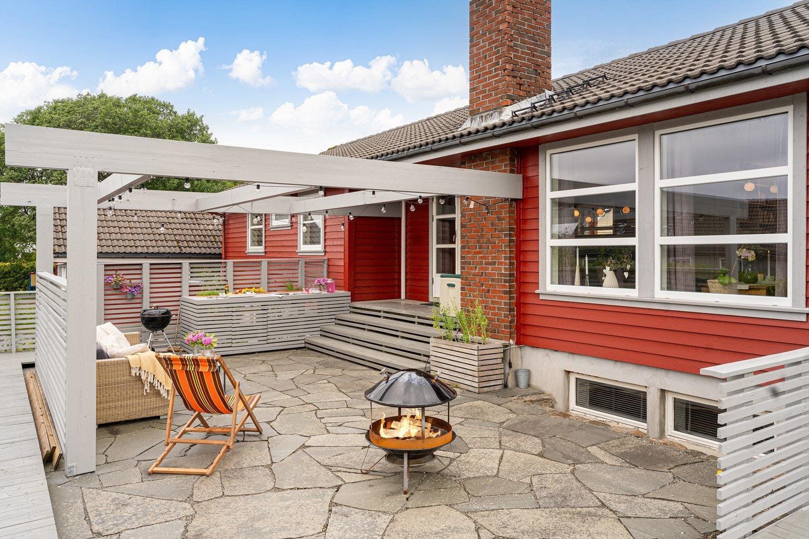 Vestvendt terrasse med skiferdekke og pergola - flere ganger benyttet med solseil/regnduk over (solseilet medfølger) Galleribilde