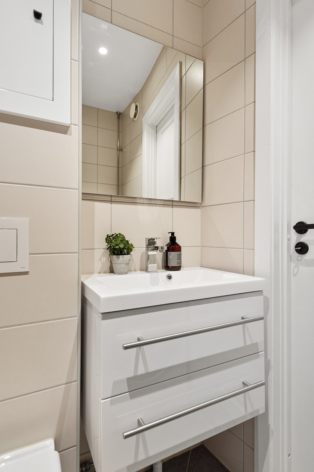 Innredning med vegghengt klosett, servantinnredning, servant med ettgreps blandebatteri, dusjdører, dusjarmatur, opplegg og plass til vaskemaskin. Galleribilde