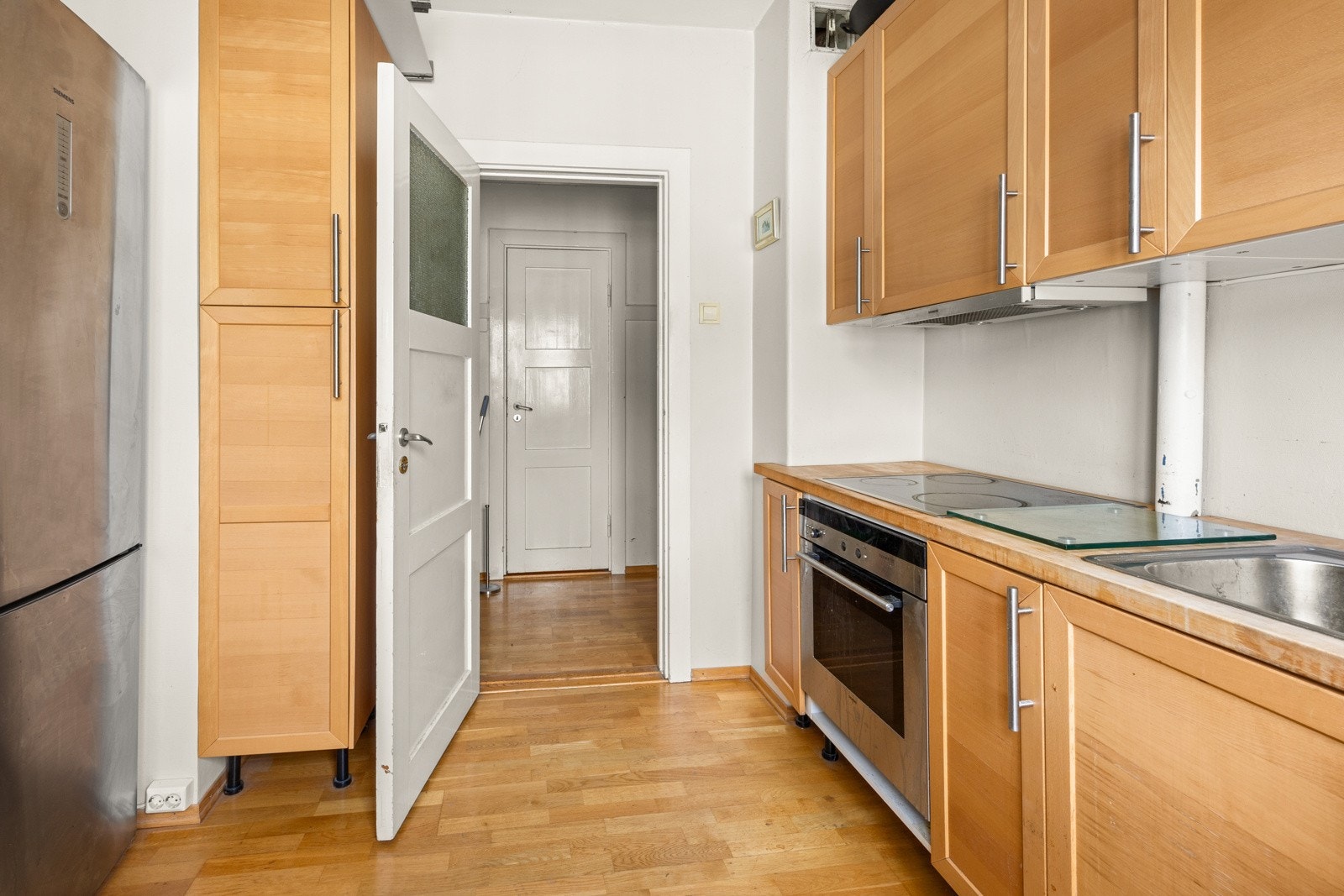 Parkett på gulv. Kjøkkeninnredning med profilerte fronter og benkeplate av tre. Galleribilde