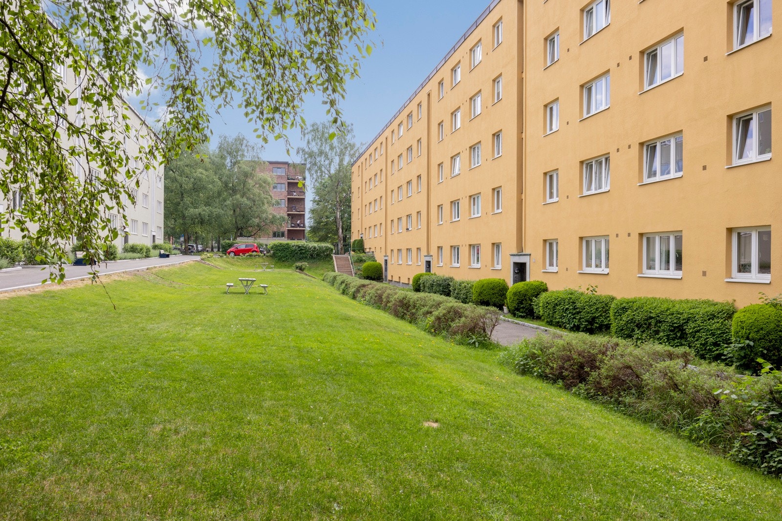 Fasade ved inngangsparti. Det er luftig mellom naboblokkene. Galleribilde