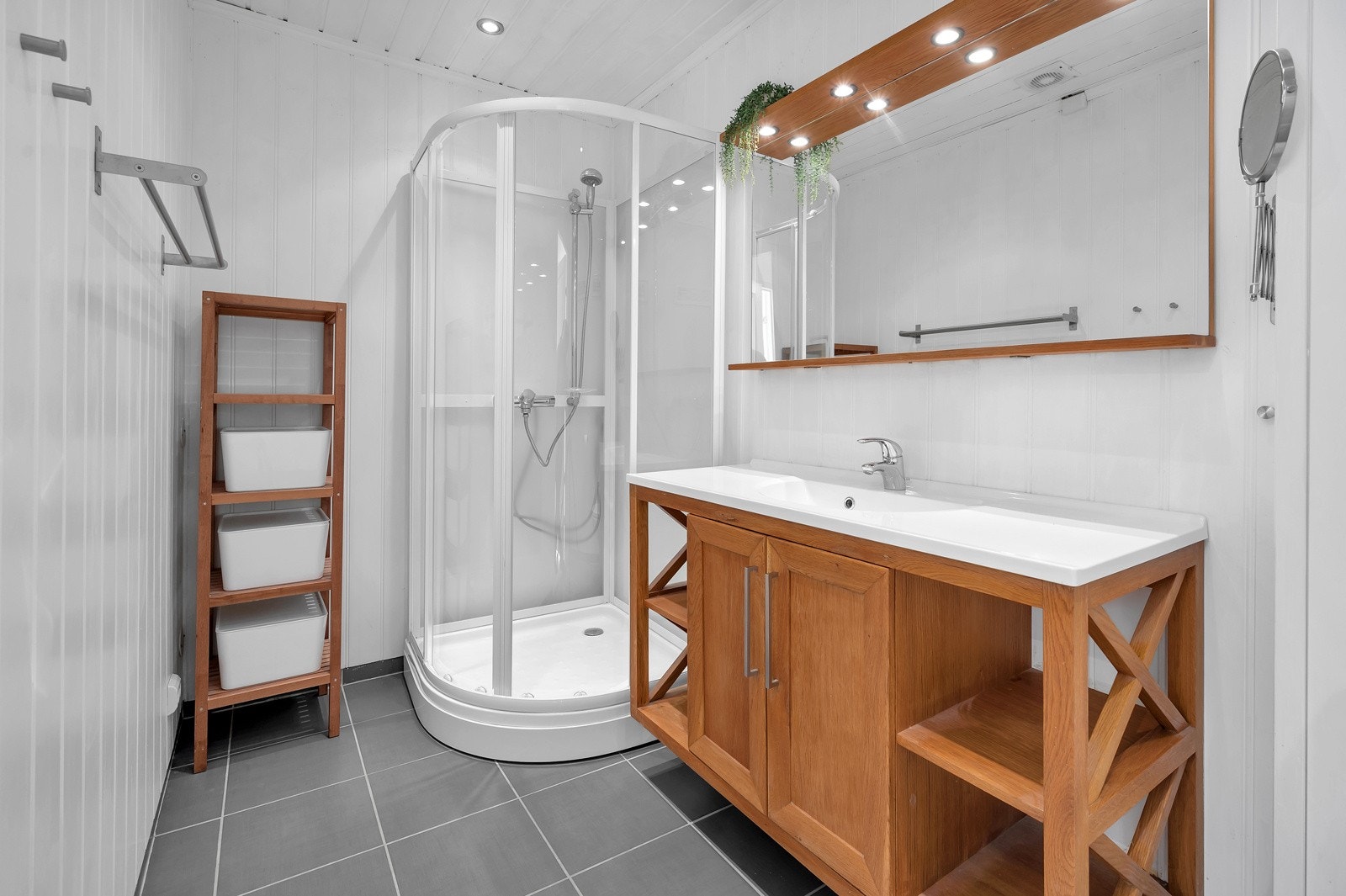 Lekkert bad med toalett, servant med speil og underskap og dusjkabinett. Galleribilde