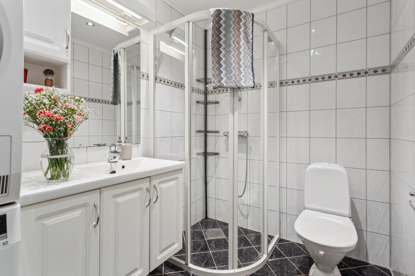 Bad med dusjvegg, servant, møbler og WC. Galleribilde