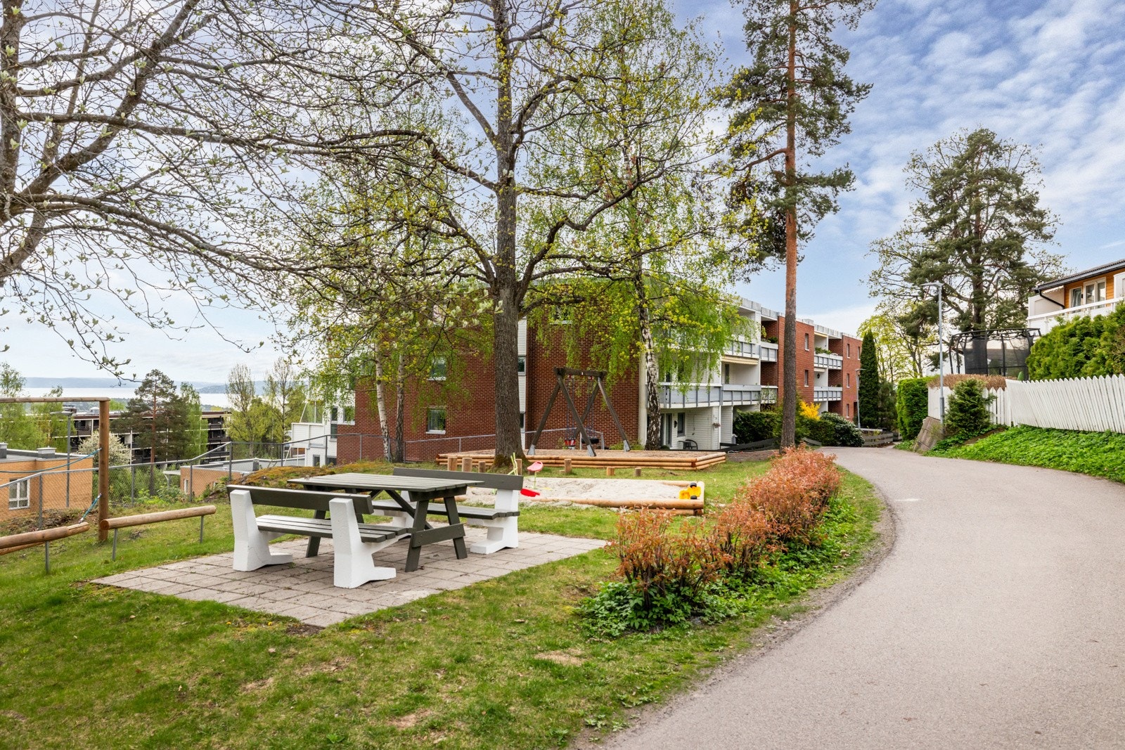 Flotte fellesområder med lekeplass og flere sittegrupper. Galleribilde