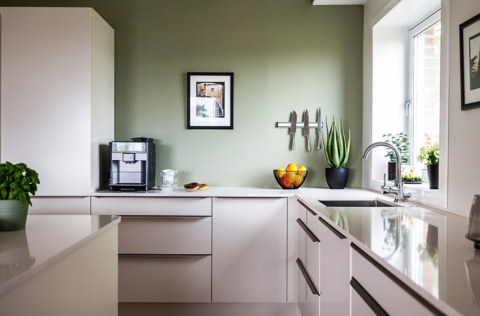 Kjøkkeninnredningen har lekre hvite fronter og benkeplate i komposittstein med nedfelt kum i rustfritt stål. Galleribilde