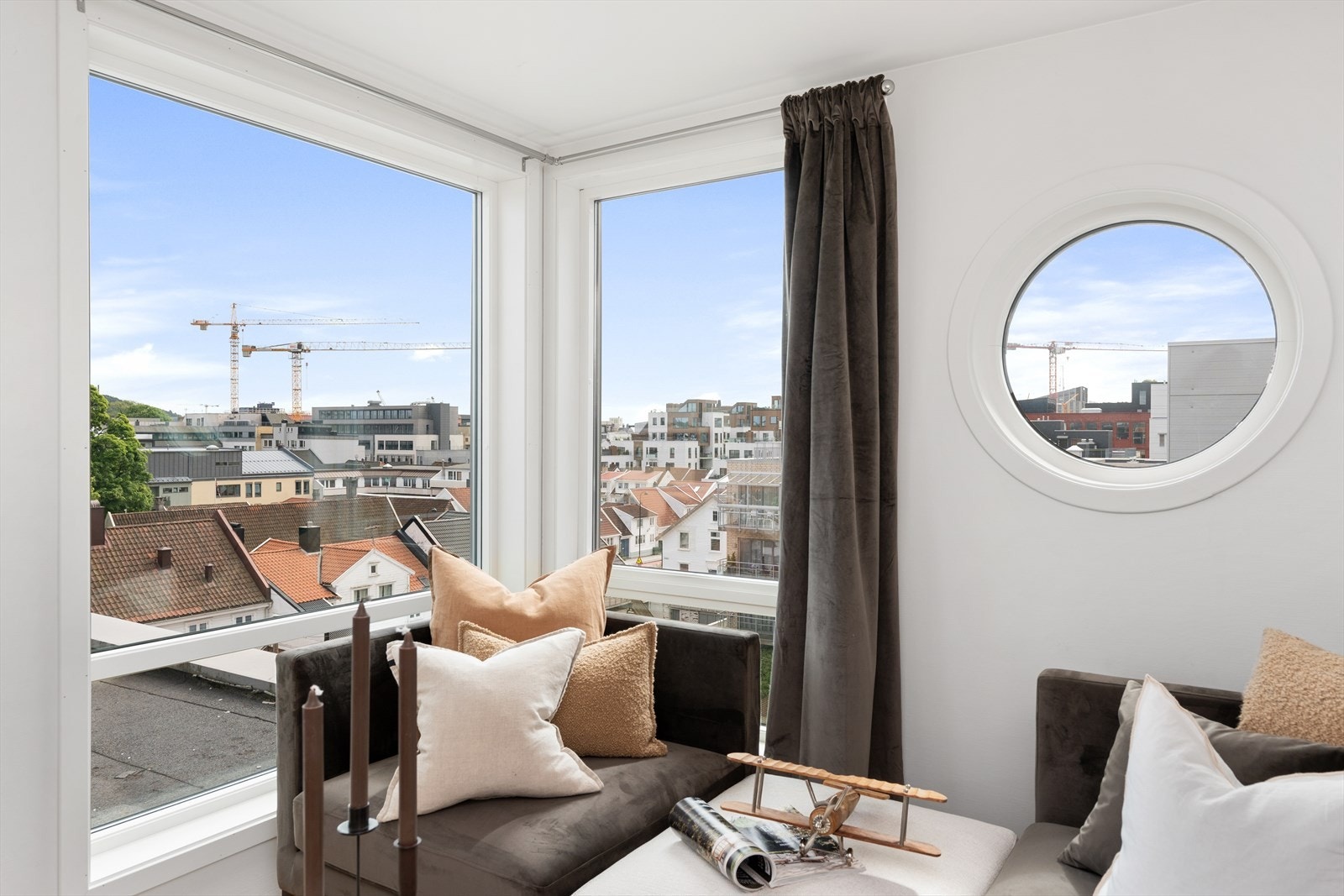 Fra den åpne stue/kjøkkenløsningen ser du utover på byens tak, heisekraner og Odderøya i det fjerne. Galleribilde
