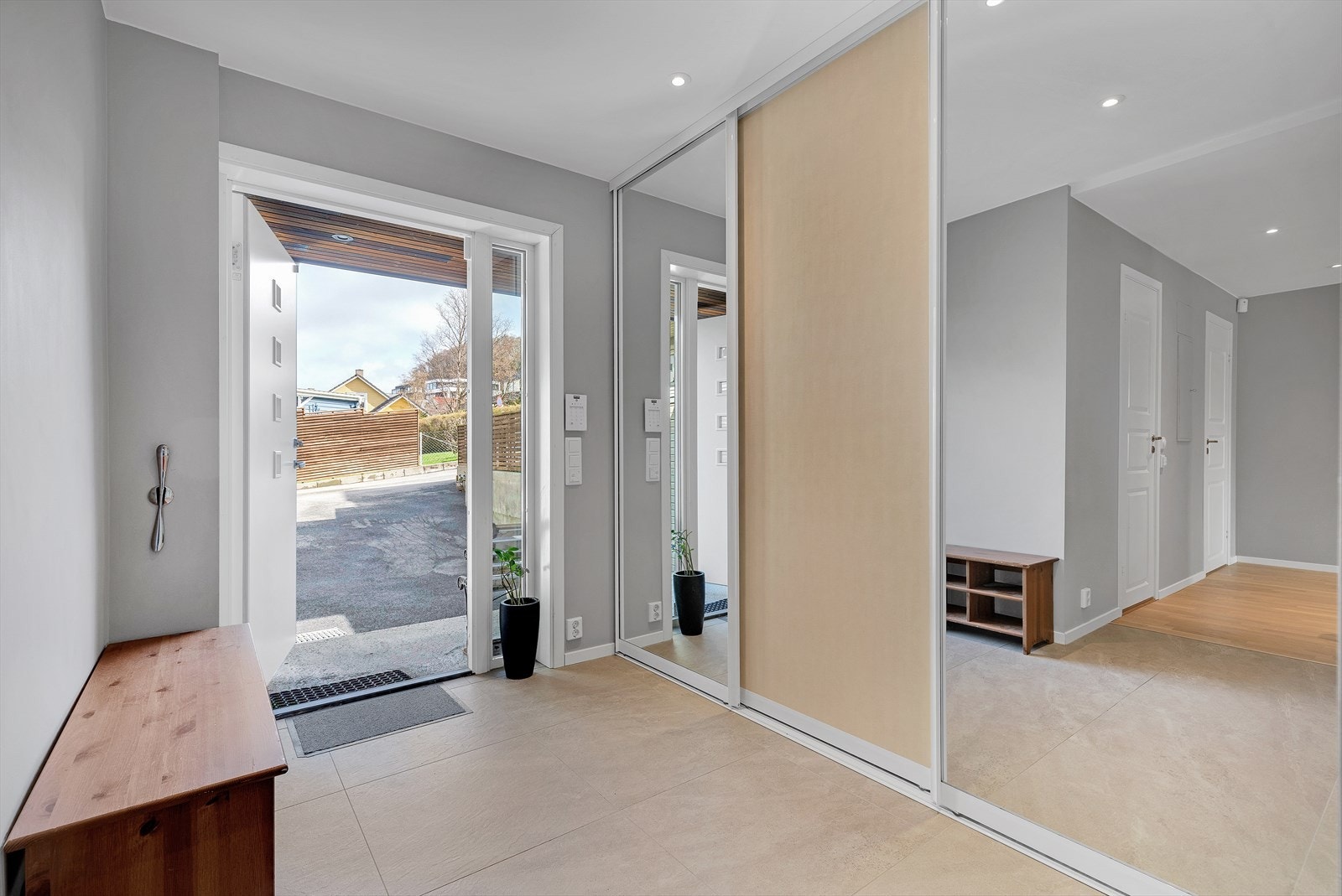 Romslig entré med flislagt gulv og stor skyvedørsgarderobe (tilbygg 2018) Galleribilde