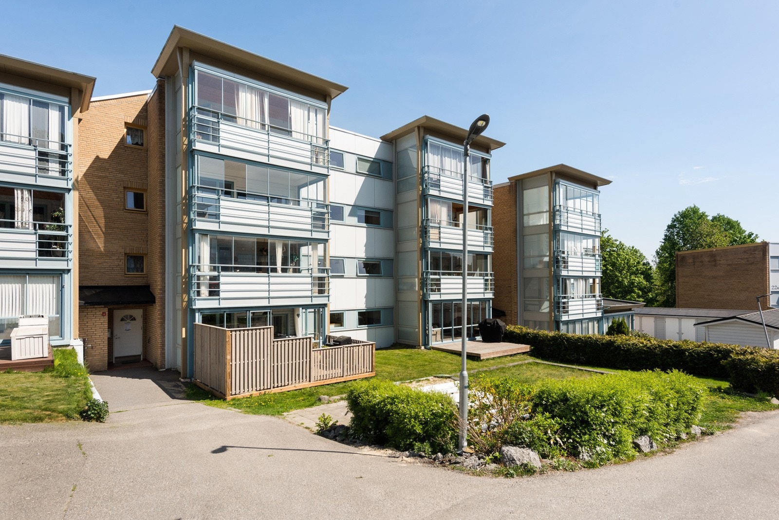 På fremsiden av bygget er det gressplen og sitteplass Galleribilde