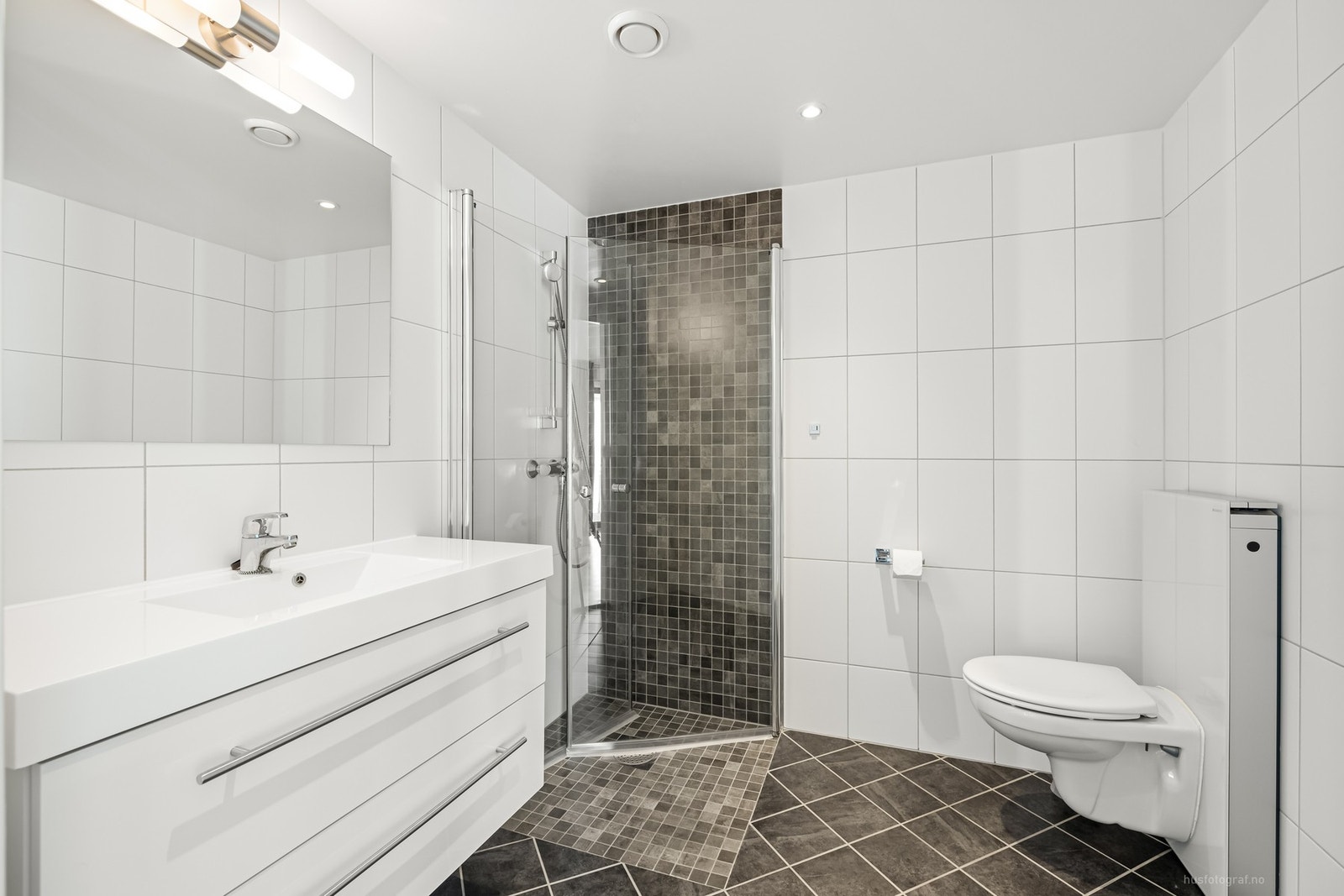 I 2. etasje finnes også et pent bad med lyse fliser, varme i gulv og downlights i himling. Galleribilde
