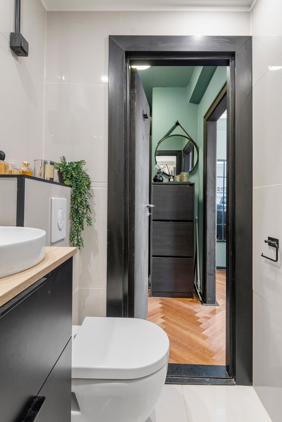 Badet er utstyrt med underskap, servant, speil, toalett og en dusjsone med dusjing direkte på gulv og vegg. Galleribilde