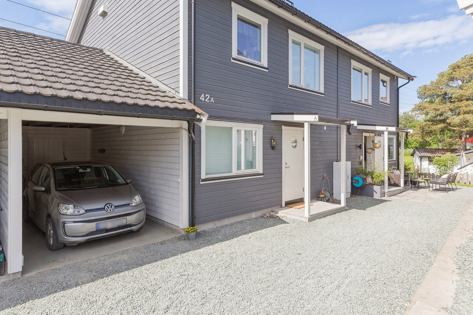 Bilen parkeres i en carport med romslig bod i bakkant. Galleribilde