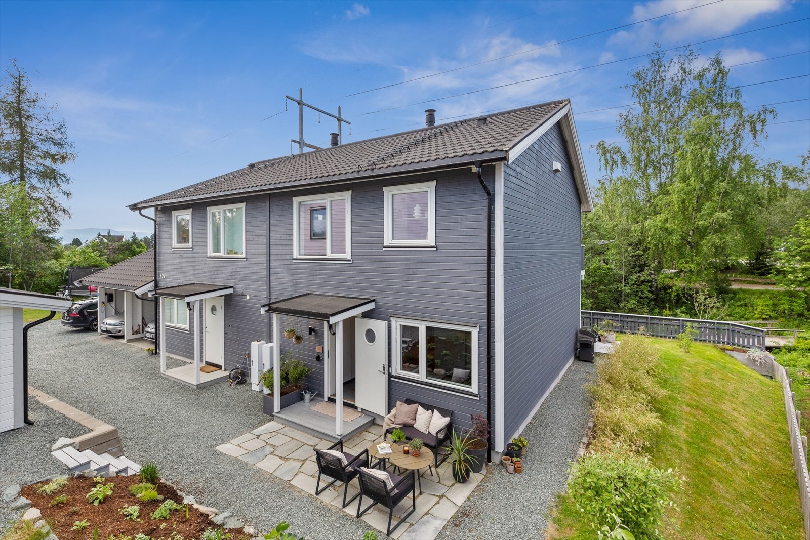 Uteområdet rundt boligen er pent opparbeidet med gjerde, busker og fine bed. Galleribilde