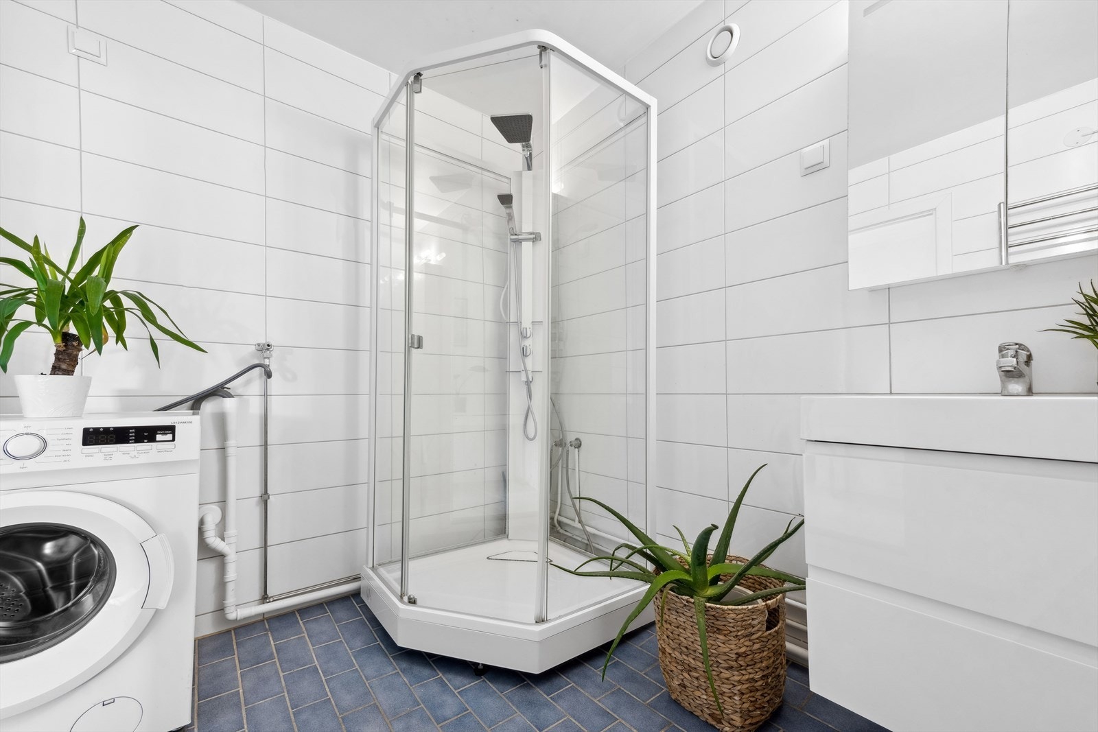 Videre har badet et dusjkabinett med en skyvbar glassdør og et to-greps blandebatteri. Galleribilde
