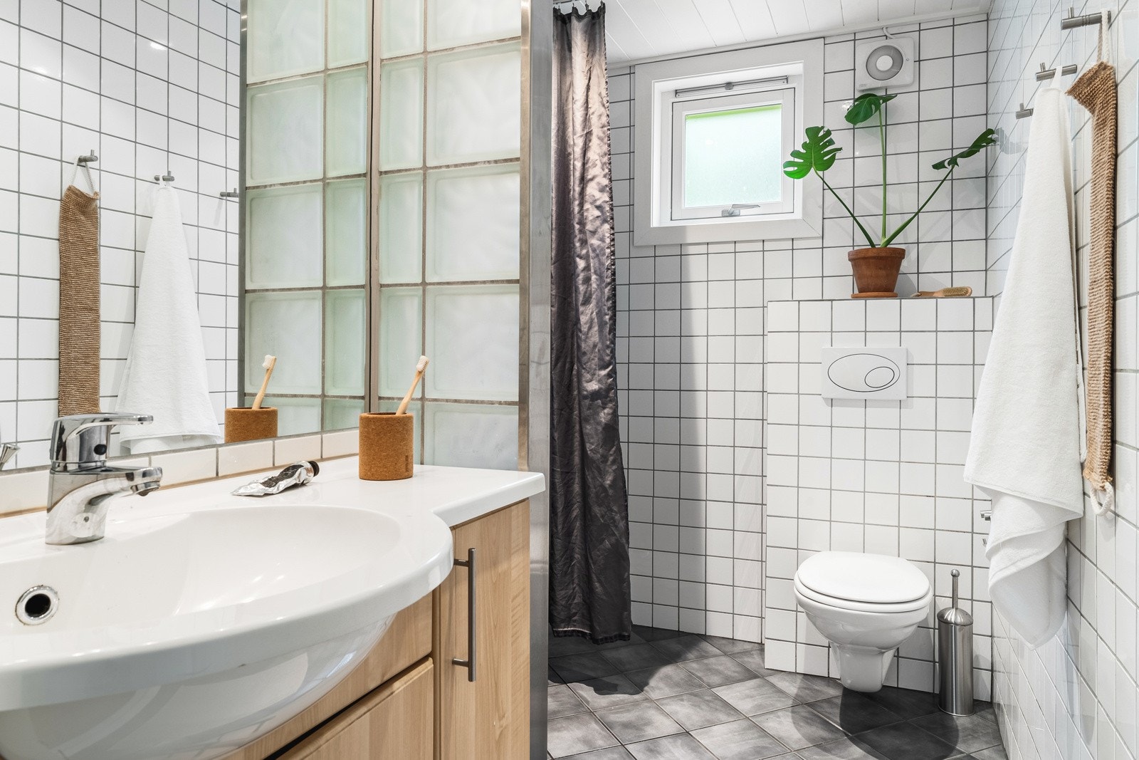 Badet i leiligheten er helfliset med varmekabler i gulv. Det ble installert ny vifte i 2023. Galleribilde