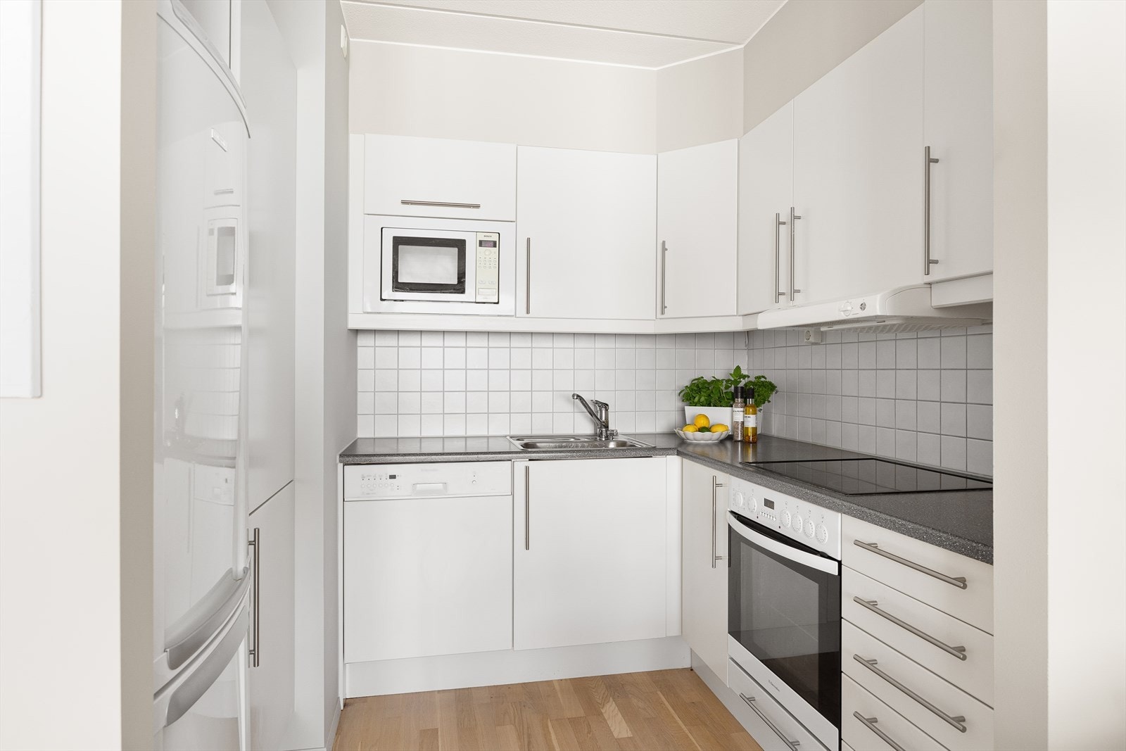 Kjøkkenet har glatte fronter og en laminatbenkeplate med en praktisk oppvaskkum. Videre er det integrert stekeovn, mikrobølgeovn, platetopp og oppvaskmaskin, som alle bidrar til å gjøre kjøkkenet både funksjonelt og stilfullt. Galleribilde