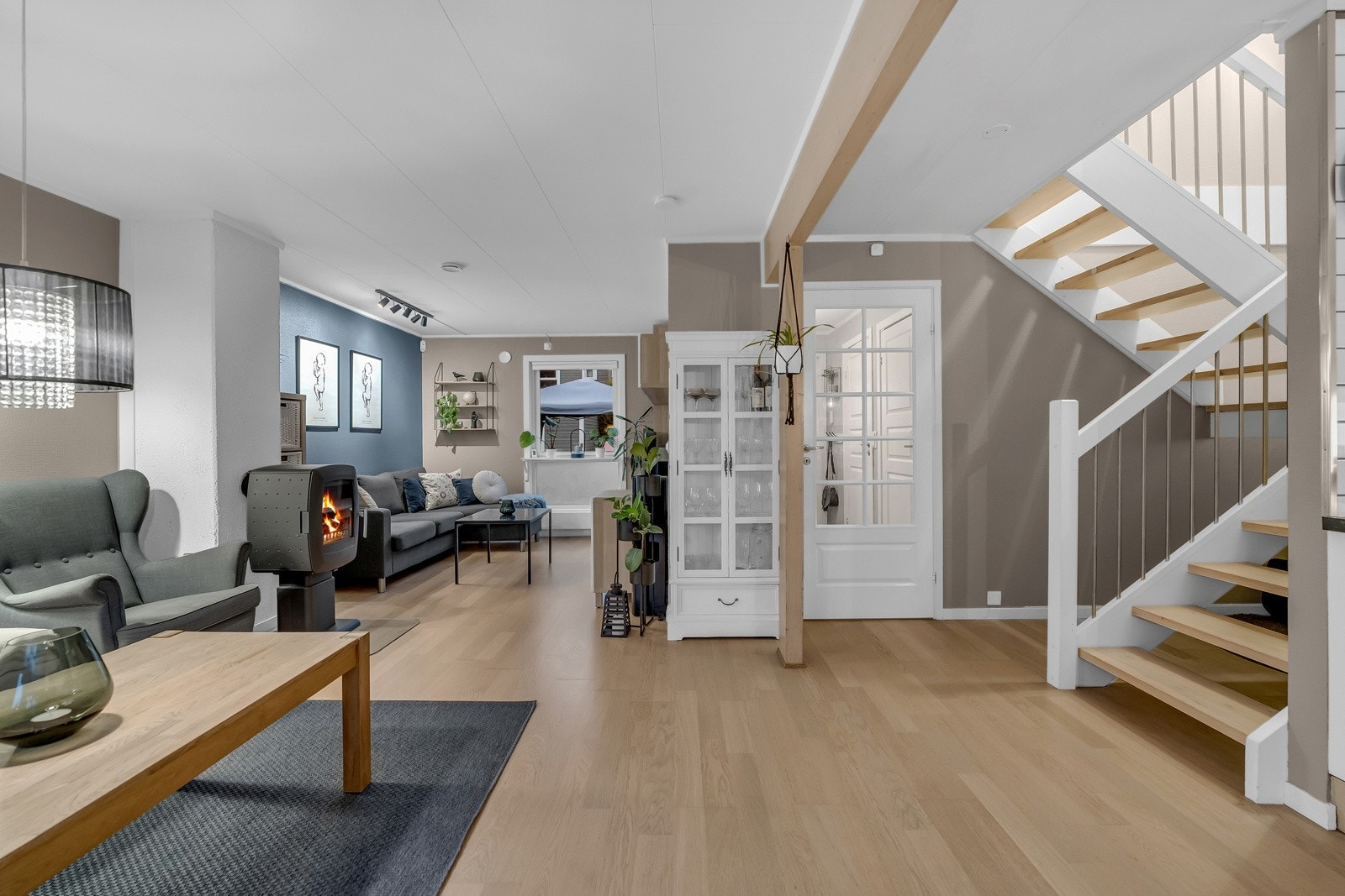 Stuen, som ligger i en åpen løsning. Gulvet og veggene harmonerer godt sammen og skaper en varm og hjemmekoselig følelse. Galleribilde
