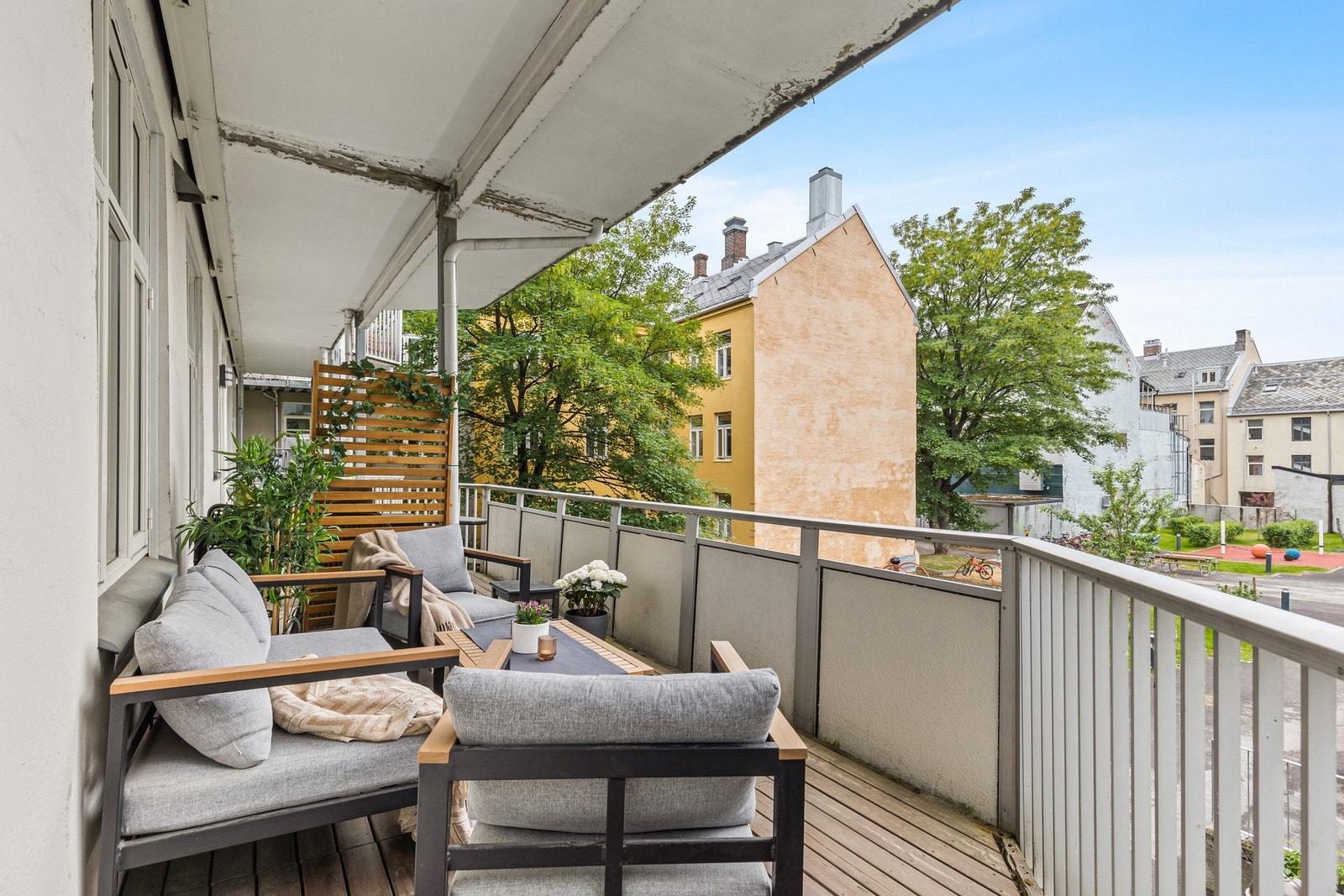 Overbygd balkong utenfor leiligheten med plass til sittegruppe. Galleribilde