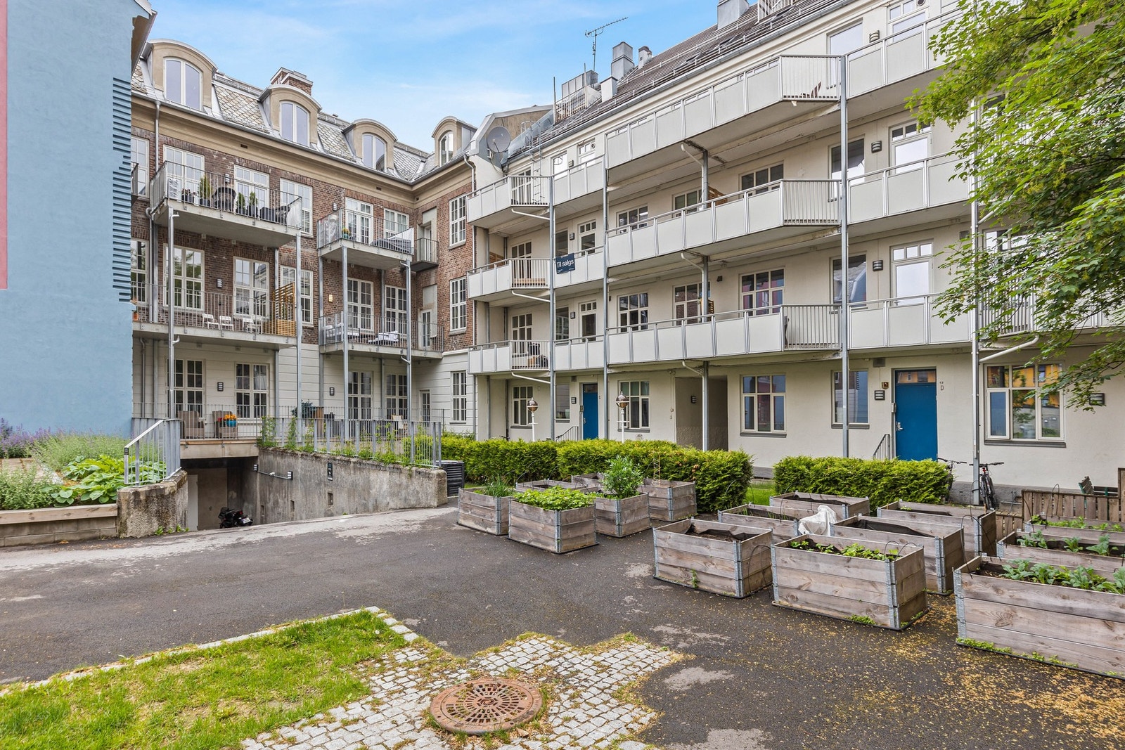Hyggelig gårdsrom med beplantning, lekeplass og benker. Galleribilde