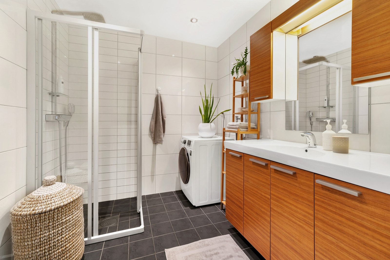 Baderommet har en moderne fremtoning med fliser på vegg og gulv, downlights i himling og dusjhjørne. Galleribilde