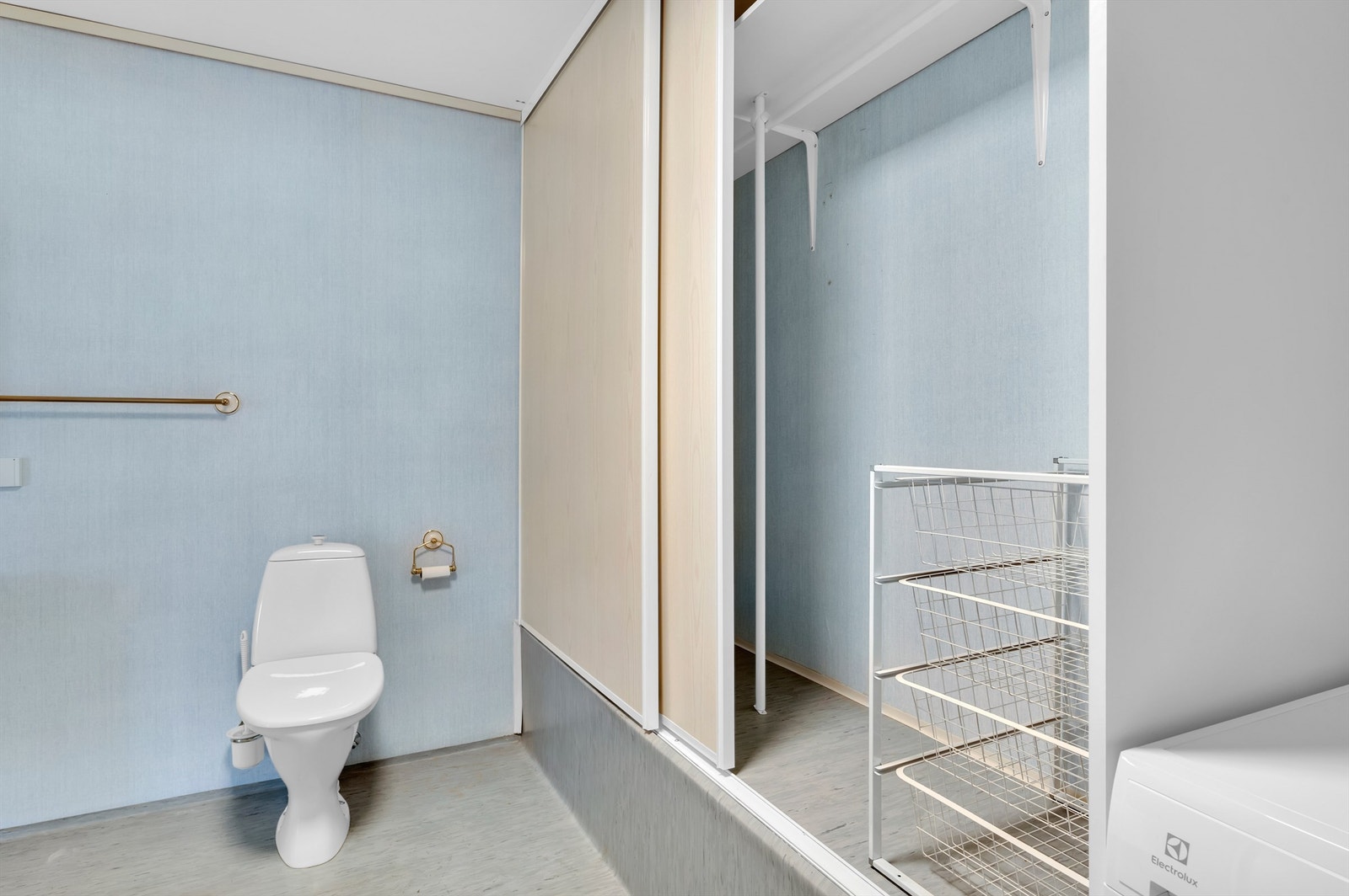 Badet har en stor skyvedørsgarderobe og opplegg for vaskemaskin. Galleribilde