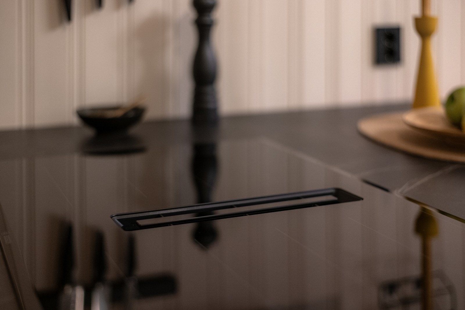 Moderne kjøkkenventilator med kullfilter ved stekesonen har utløp under kjøkkeninnredningen. Galleribilde