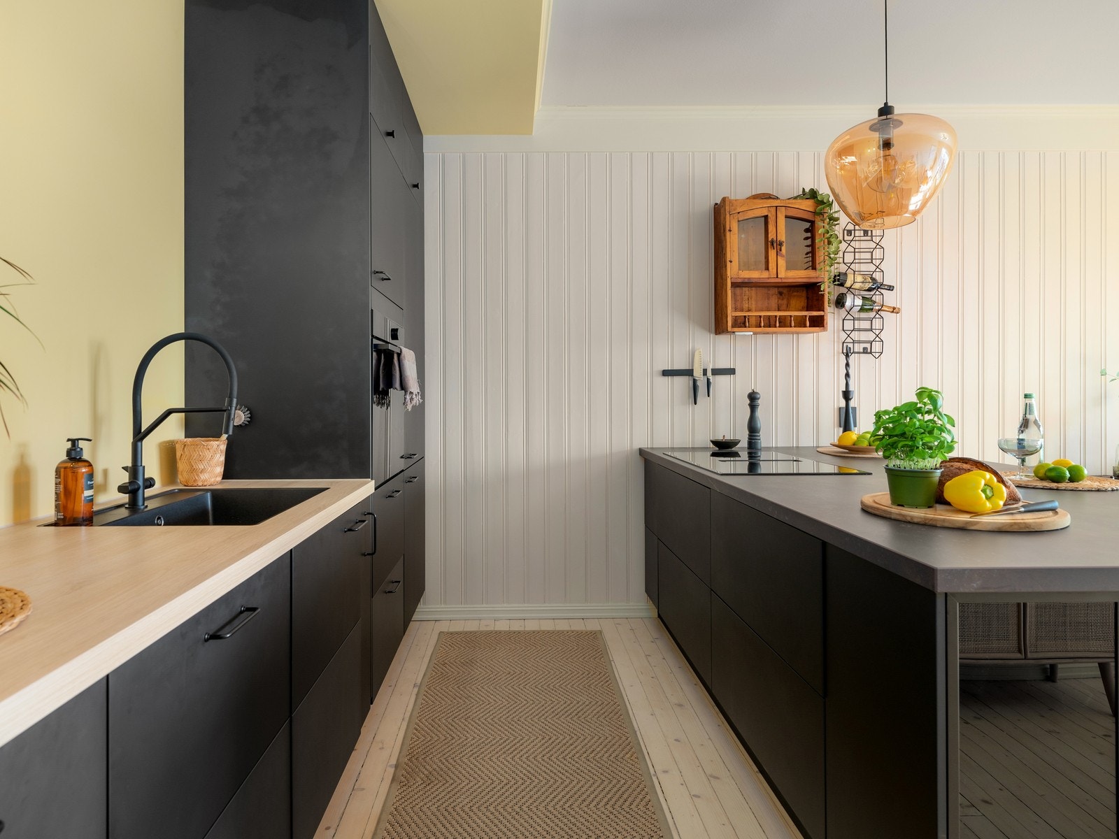 Kjøkkenet er designet med praktisk kjøkkenøy og rikelig med skap- og benkeplass på begge sider av øyen. Galleribilde