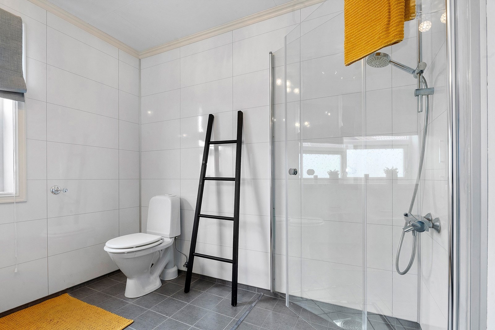Badet er pent innredet med baderomsinnredning, WC og dusjhjørne med innfellbare dusjvegger. Galleribilde