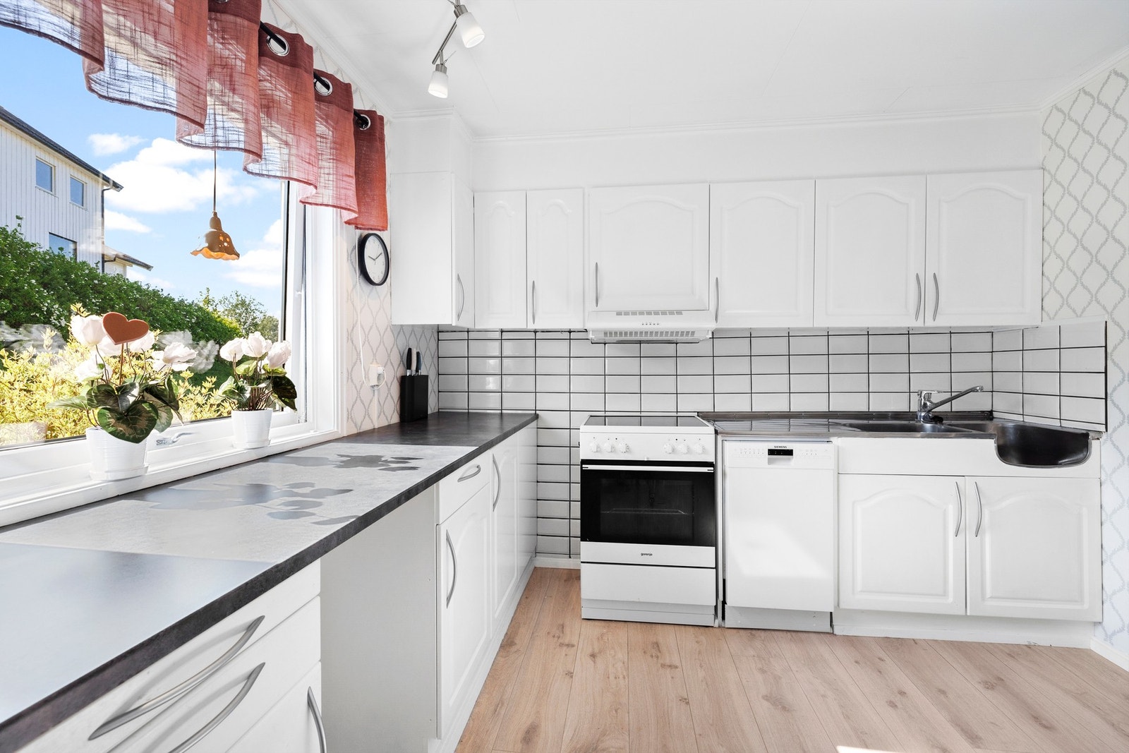 Kjøkkeninnredning med profilerte hvite fronter og benkeplate av laminat Galleribilde