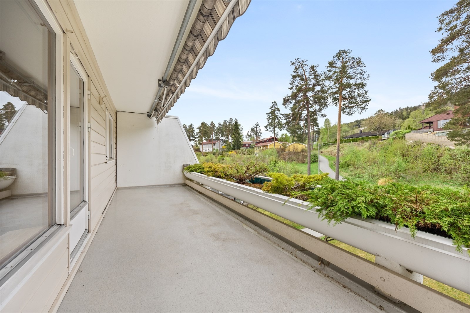 Romslig terrasse med
blomsterkasser og markise. Galleribilde