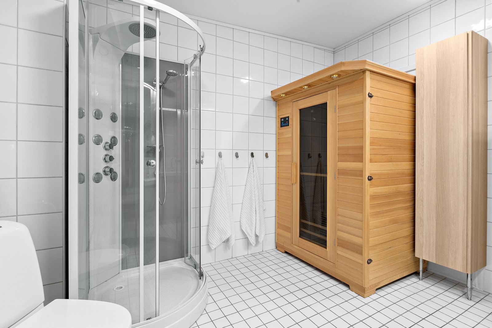 Badet er av god størrelse på 8,8 kvm og inneholder dusjkabinett, badstue, toalett, opplegg til vaskemaskin og baderomsinnredning med dobbelservant Galleribilde