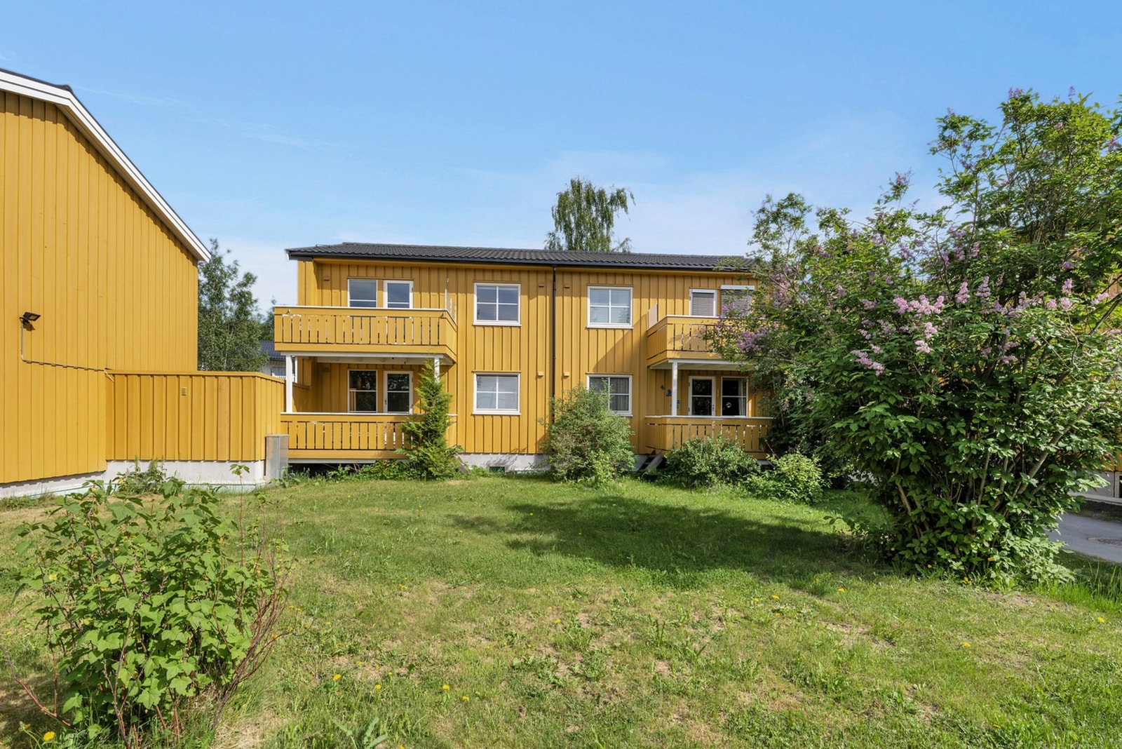 Store felles hage hvor plenen klippes av vaktmesteren til borettslaget. De grønne fellesarealene rundt boligen gir en ekstra koselig følelse. Galleribilde